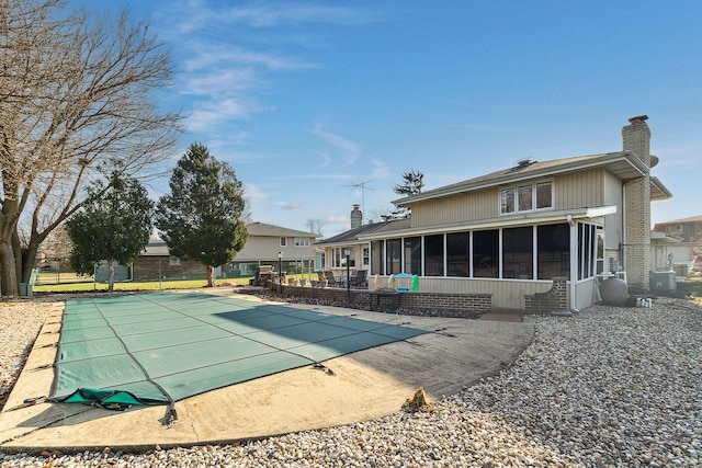 view of swimming pool with a patio and a sunroom