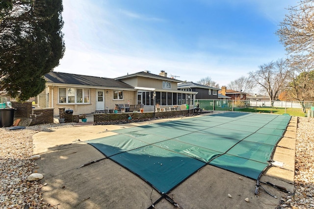 view of swimming pool with a sunroom and a patio