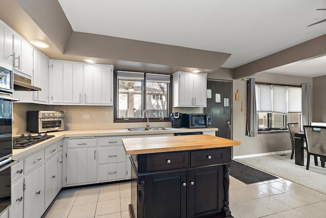 kitchen featuring white cabinets, light tile patterned flooring, and sink