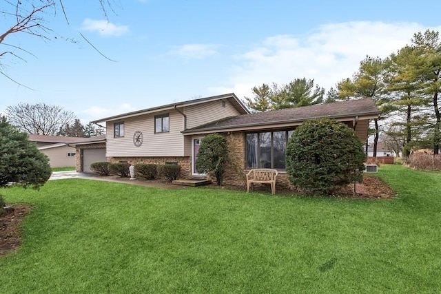 rear view of property featuring a yard and a garage