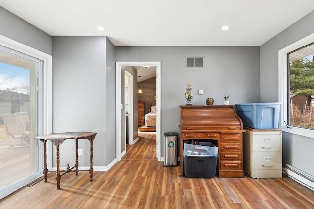 office area with a baseboard radiator and wood-type flooring