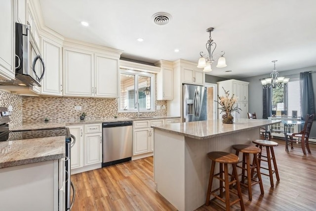 kitchen featuring plenty of natural light, a center island, appliances with stainless steel finishes, and a chandelier