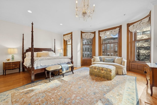 bedroom featuring an inviting chandelier, crown molding, and light hardwood / wood-style floors