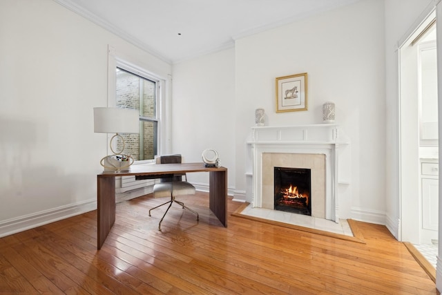 office space featuring a fireplace, wood-type flooring, and ornamental molding