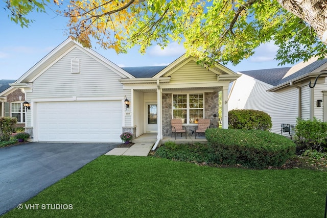 view of front of property featuring a porch, a garage, and a front lawn