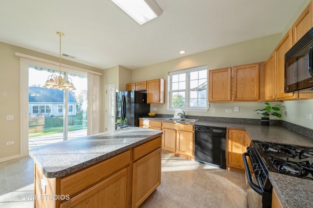 kitchen with sink, black appliances, pendant lighting, an inviting chandelier, and a center island