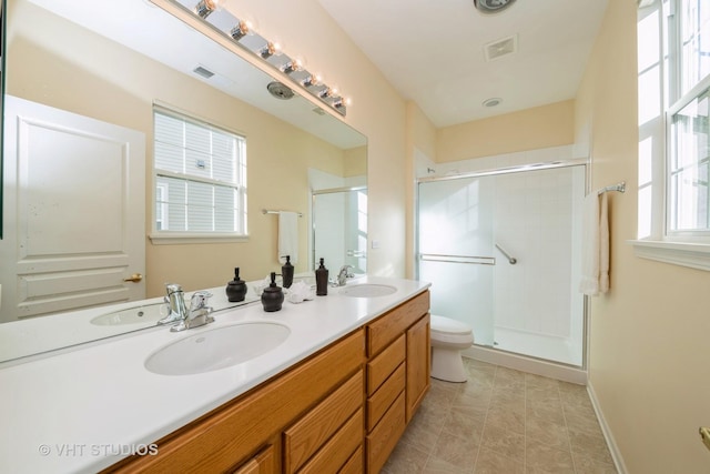 bathroom with vanity, toilet, and a shower with door