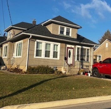 bungalow-style home with a front lawn