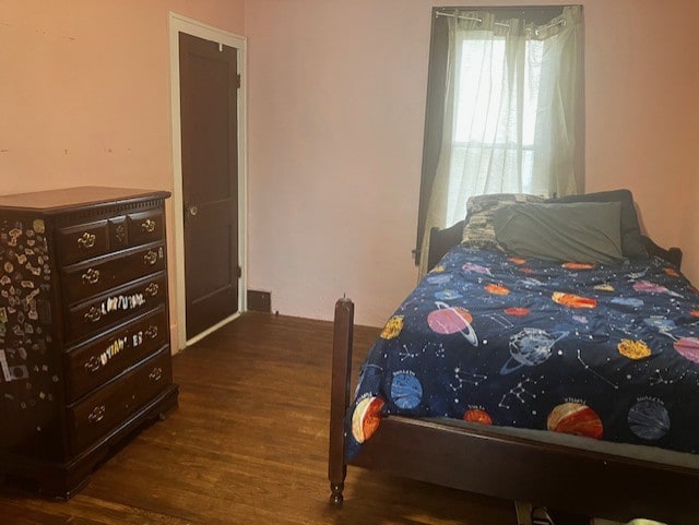 bedroom with dark wood-type flooring