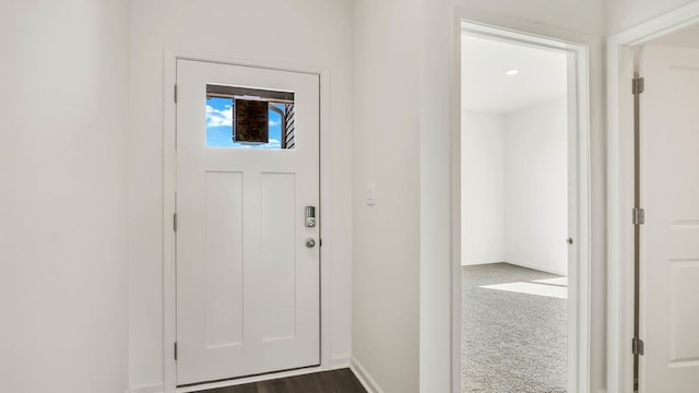 entrance foyer with dark colored carpet