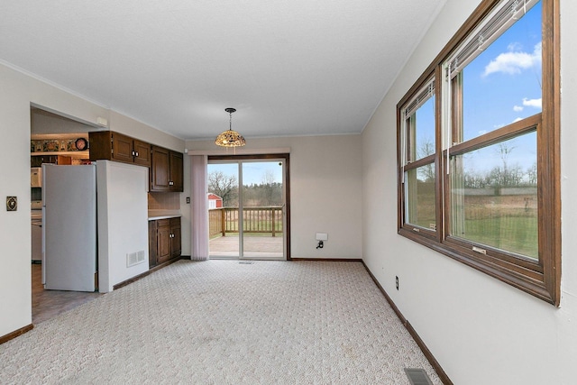 interior space featuring baseboards, visible vents, and light colored carpet