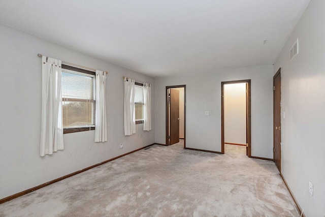 empty room with light carpet, baseboards, and visible vents