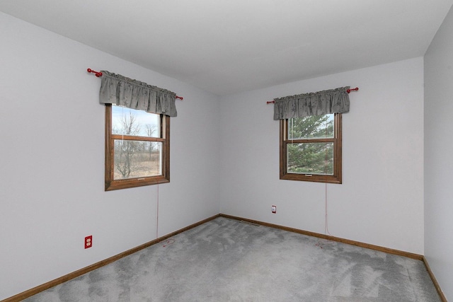 unfurnished room with carpet flooring, plenty of natural light, and baseboards