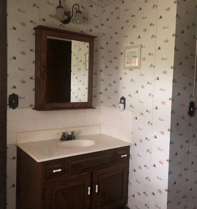 bathroom with vanity and wallpapered walls