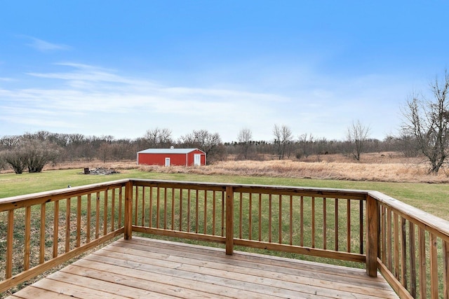 wooden deck featuring an outbuilding, a yard, and a rural view