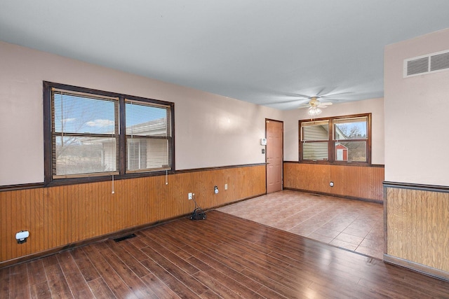 unfurnished room featuring wainscoting, visible vents, and wood finished floors