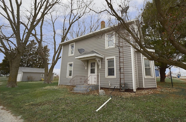 view of front of property featuring an outbuilding and a front lawn