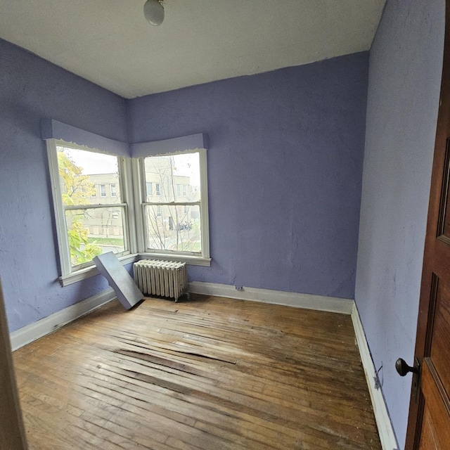 spare room with hardwood / wood-style flooring and radiator