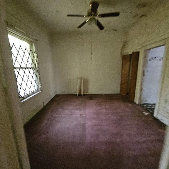 carpeted empty room with ceiling fan and a healthy amount of sunlight