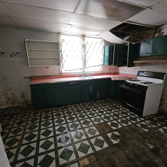 kitchen featuring a drop ceiling, white gas range, and sink