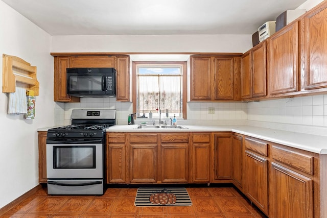 kitchen featuring backsplash, stainless steel gas stove, and sink