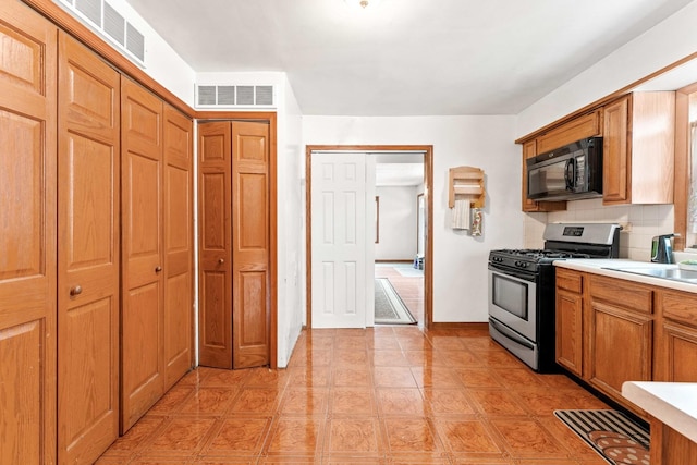 kitchen with backsplash and stainless steel gas range