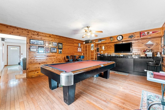 recreation room featuring light hardwood / wood-style flooring, ceiling fan, wooden walls, and pool table