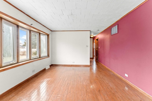 unfurnished room with light wood-type flooring and crown molding