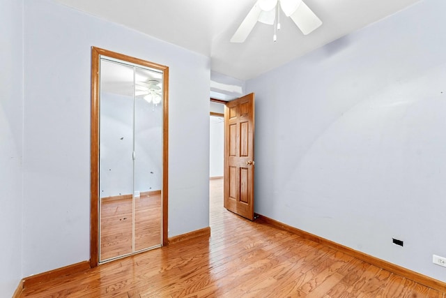 unfurnished bedroom with ceiling fan, a closet, and light wood-type flooring