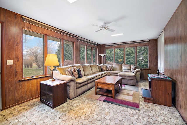 living room with wood walls and ceiling fan