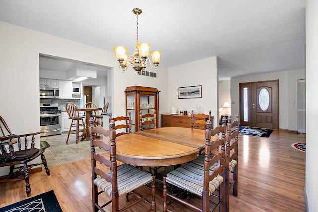 dining space featuring a chandelier and light wood-type flooring