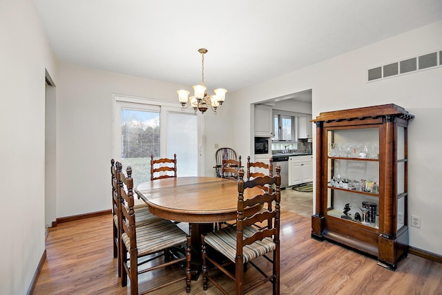 dining area featuring light hardwood / wood-style floors and a chandelier