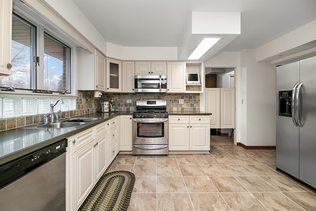 kitchen featuring appliances with stainless steel finishes, tasteful backsplash, light tile patterned floors, and sink