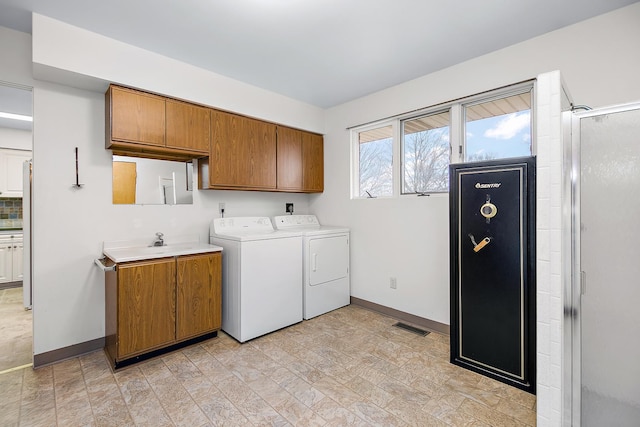 washroom featuring cabinets, sink, and washer and dryer