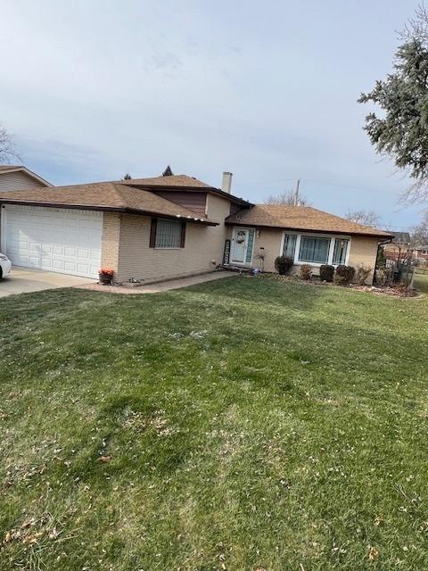 ranch-style house with a garage and a front lawn