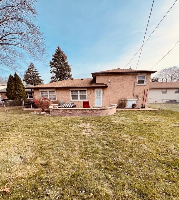 rear view of property featuring a lawn