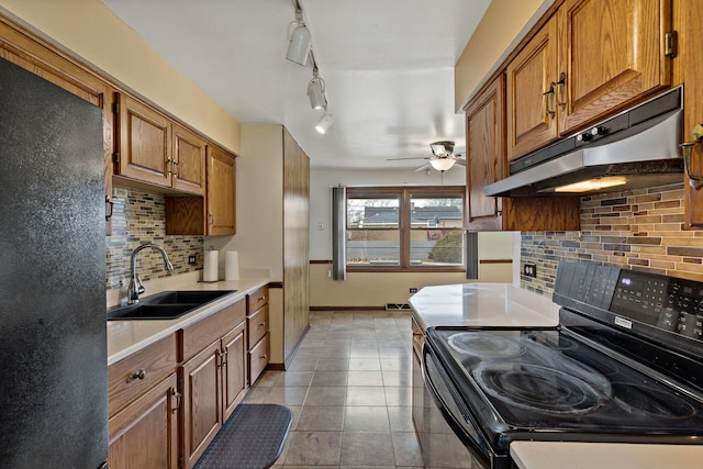 kitchen featuring sink, backsplash, light tile patterned floors, ceiling fan, and black appliances