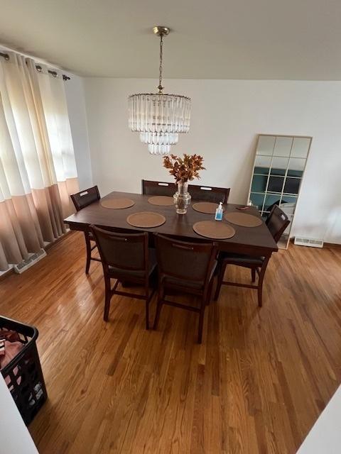 dining room featuring wood-type flooring and a notable chandelier