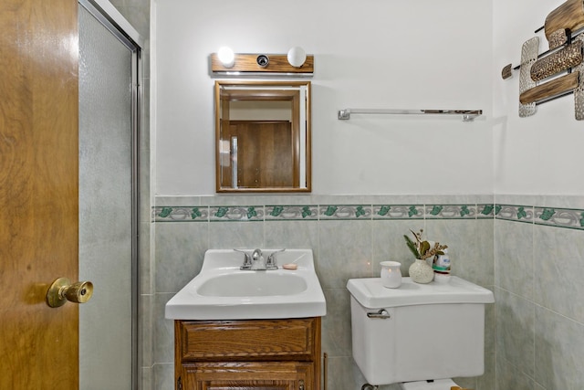 bathroom with vanity, tile walls, and toilet