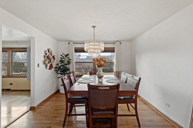 dining room with hardwood / wood-style flooring and a notable chandelier