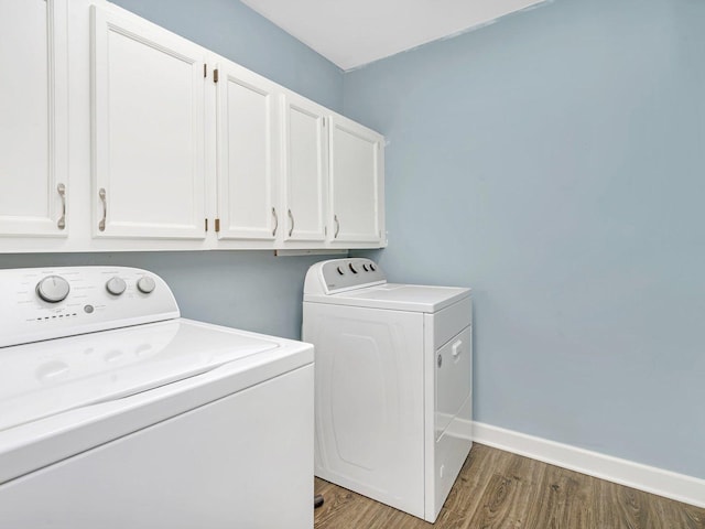 laundry area featuring cabinets, independent washer and dryer, and dark hardwood / wood-style floors