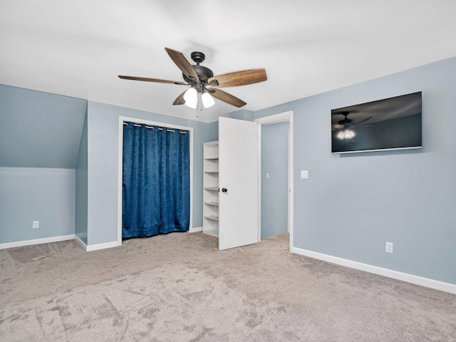 unfurnished bedroom featuring ceiling fan, carpet floors, and vaulted ceiling