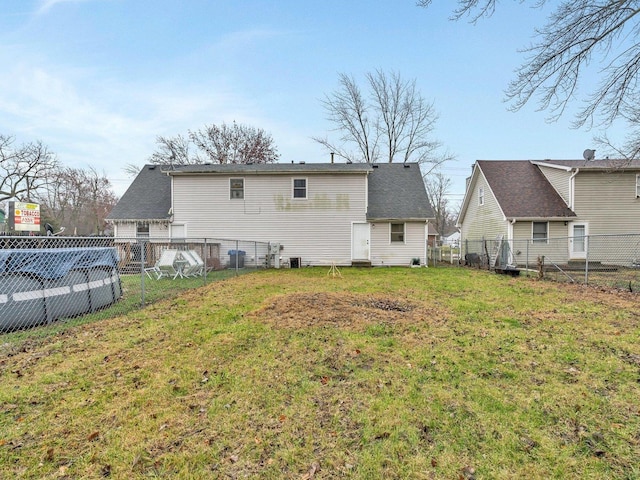 rear view of property featuring central AC unit, a yard, and a covered pool