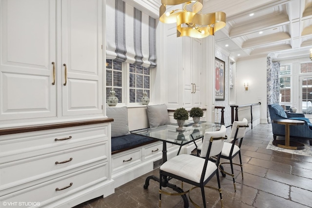 dining space with beam ceiling, crown molding, coffered ceiling, and an inviting chandelier