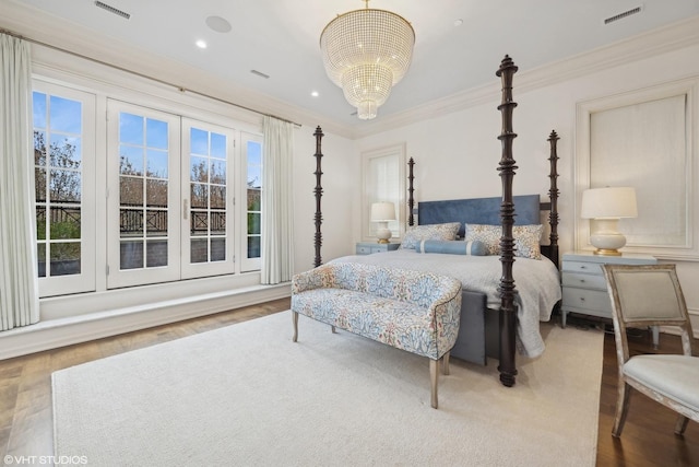 bedroom featuring hardwood / wood-style flooring, a notable chandelier, ornamental molding, and multiple windows