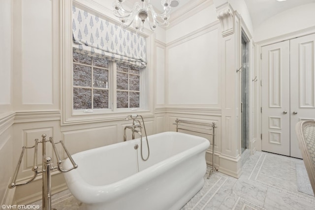 bathroom featuring a bathing tub, crown molding, and an inviting chandelier