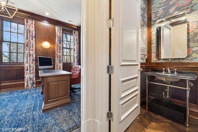 home office with dark parquet flooring and sink