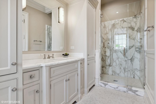 bathroom with vanity, a shower with shower door, and crown molding