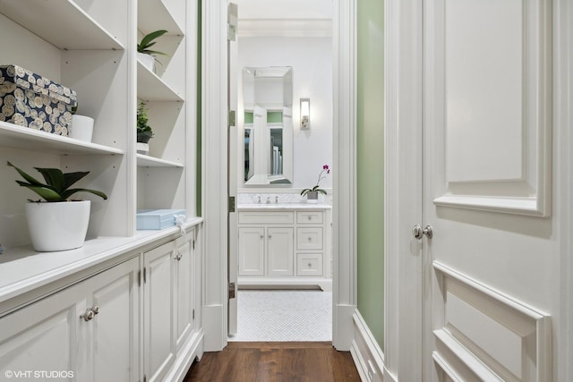 interior space featuring vanity, wood-type flooring, and crown molding