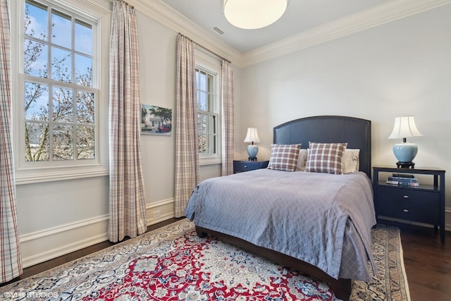 bedroom with ornamental molding, multiple windows, and dark wood-type flooring